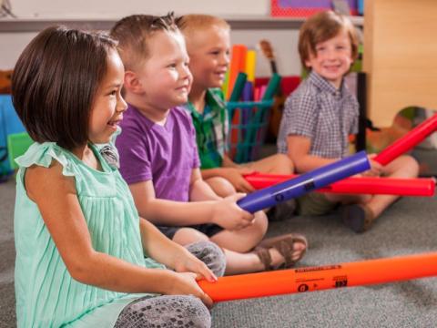 children holding colorful plastic tubes