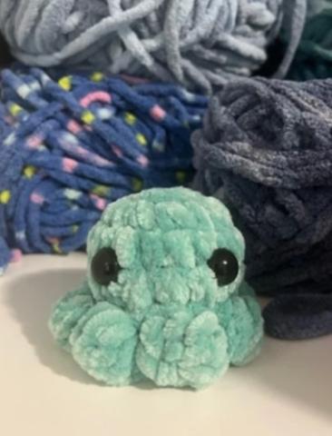 green crochet octopus with yarn