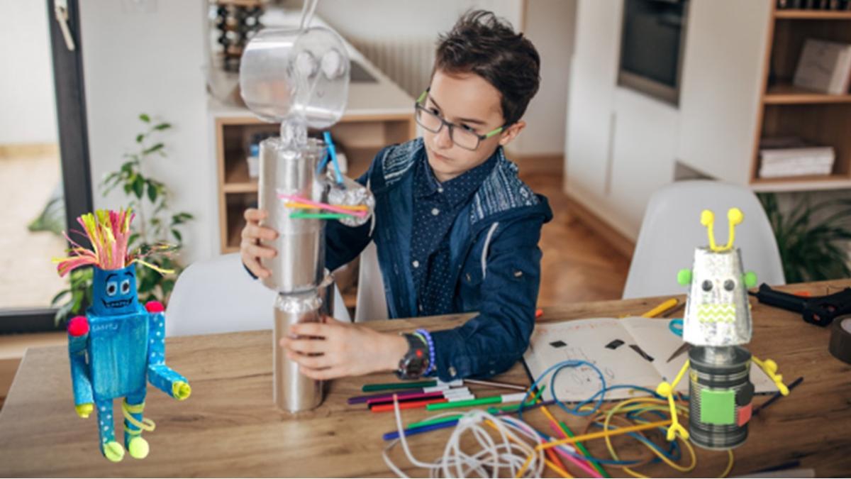 Boy constructing a robot from recycled materials